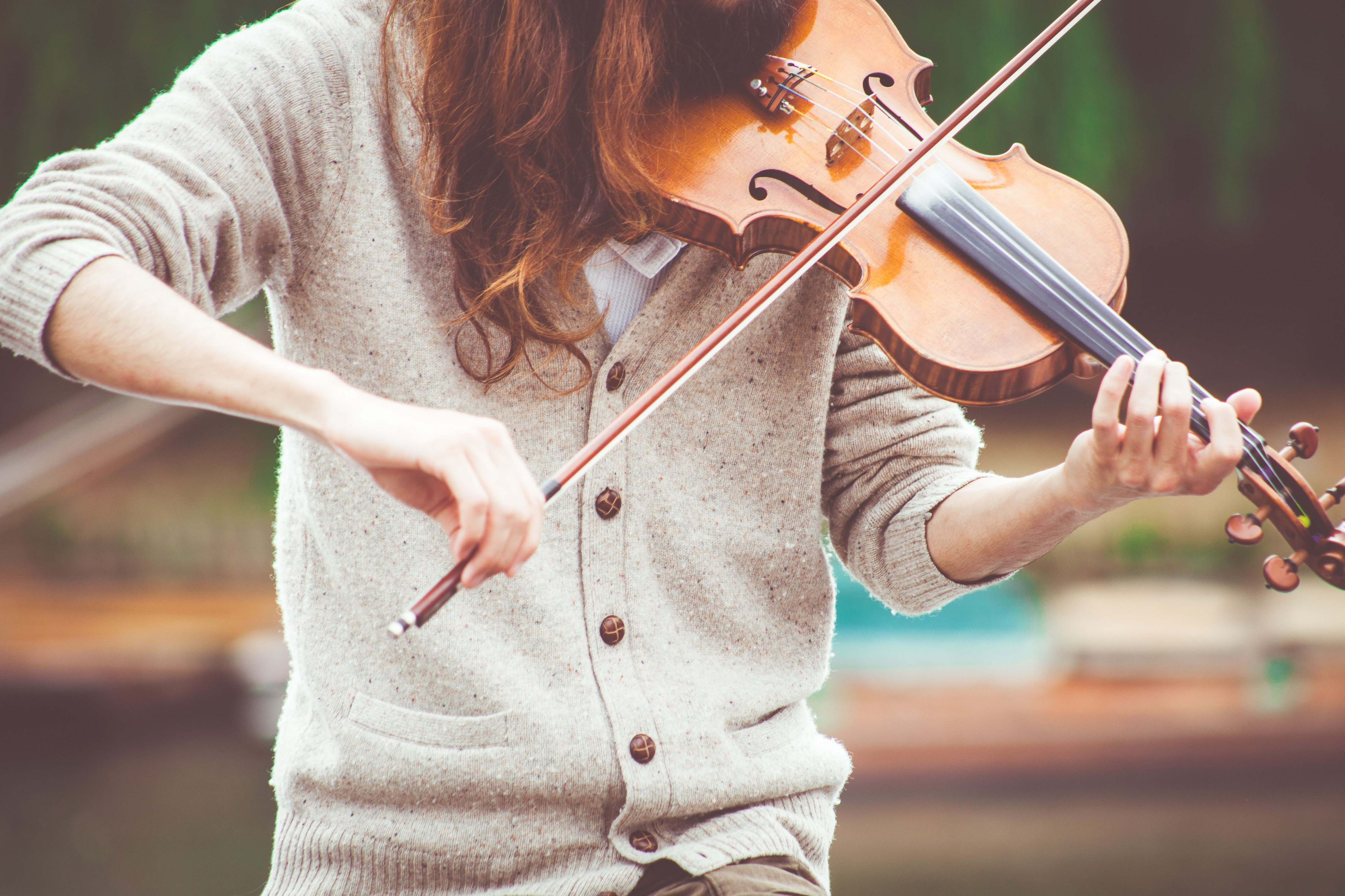 woman in a sweater playing the violin